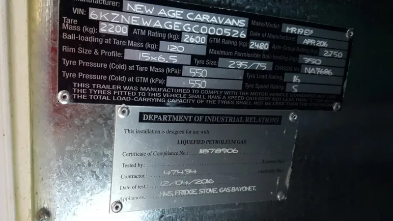 Compliance plate photo: A New Age compliance plate showing ATM, GTM and tare, photographed near the door or A-frame.